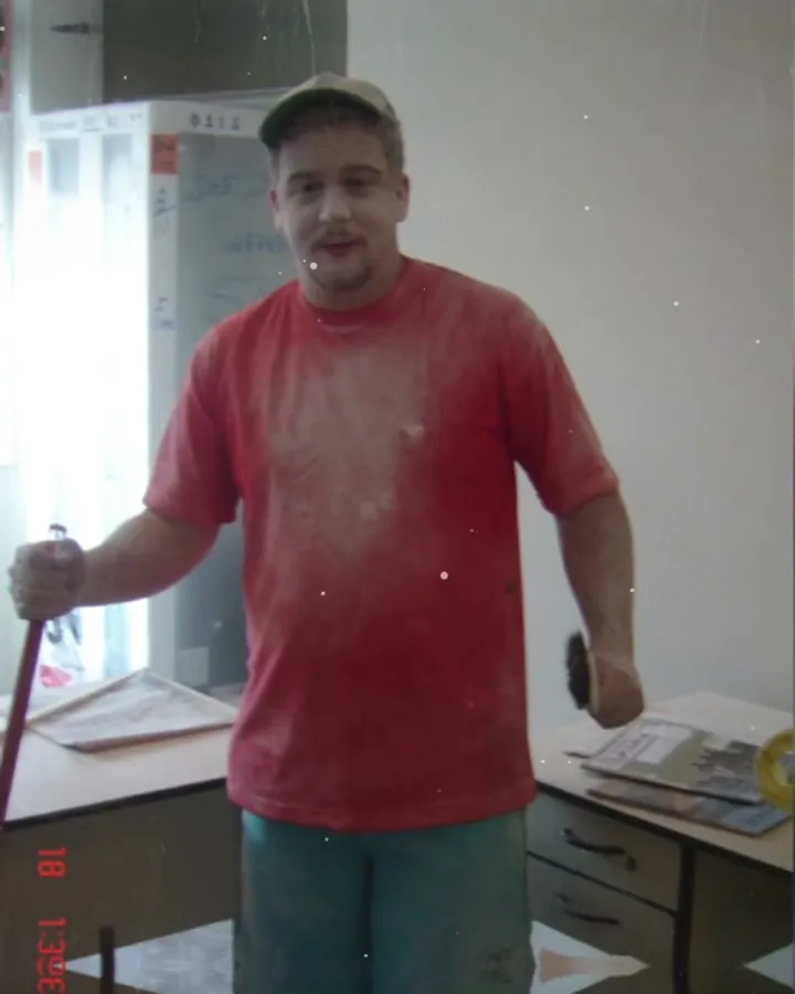 Marcio Menegatti em 2004, de camiseta e boné, com o pincel na mão, pintando a sala do novo escritório da Província